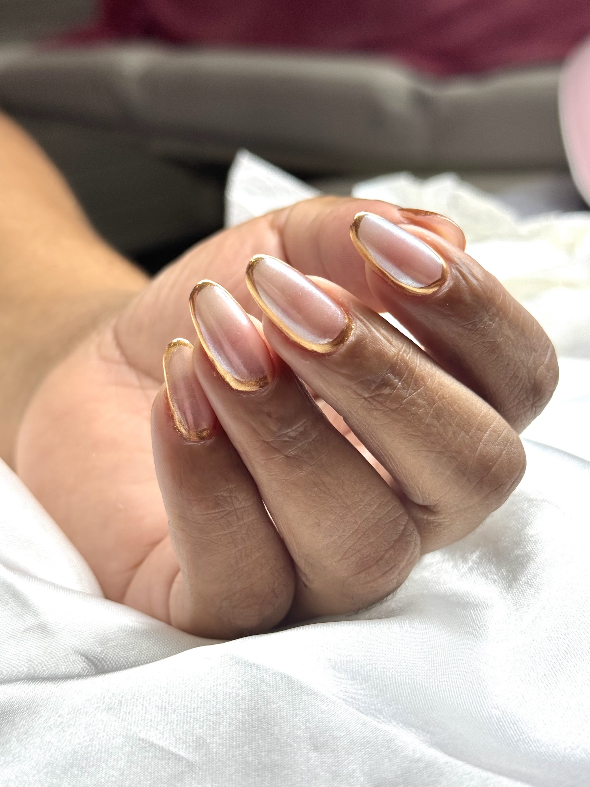 Hand met nude nagels met een gouden rand